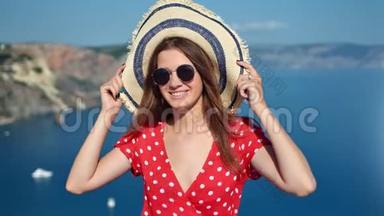 戴着墨镜、戴着草帽的年轻女子微笑着，手持草帽，摆着天然海洋背景