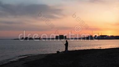 码头上令人难以置信的粉红色日落，前面是带着钓竿的孤独渔夫