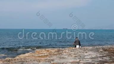一个<strong>孤独的</strong>老人坐在空海滩上，拿着投饵棒和钓鱼。 <strong>孤独的</strong>渔夫在海滩上