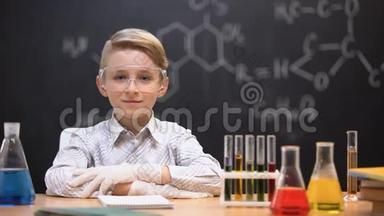 坐在防护眼镜里的小天才，桌子上的管子里有化学液体