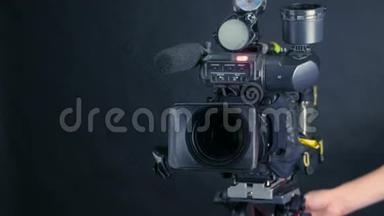 摄像机操作员在无法辨认的电视新闻演播室与一个电影院广播摄像机合作。