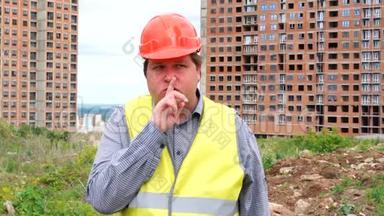 建筑工地上的建筑工人在要求保持沉默时，用一个嘘声的手势把手指举到嘴唇上