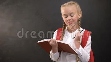 梦幻般的小女生在笔记本上写字，靠着<strong>黑板做作业</strong>
