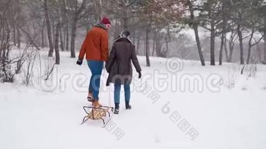 可爱的一对夫妇在下雪的冬天散步拉雪橇。 有女朋友的人会在下雪的时候滑雪。 女人要去