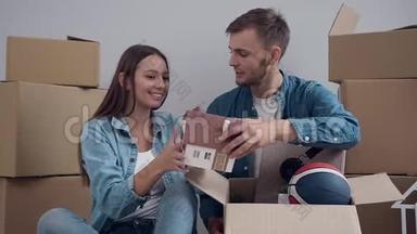 兴奋的年轻夫妇打开东西，打开盒子，在搬到新公寓时交谈。