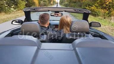 快乐的年轻夫妇在驾驶<strong>敞篷</strong>车时拥抱着。