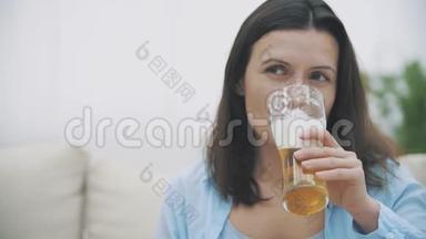 慢点。 微笑<strong>开</strong>朗的女人正在喝啤酒，坐在家里的沙发上。 复制空间。 快<strong>关门</strong>。 4K.