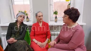老年妇女坐在退休者俱乐部的<strong>朋友聚会</strong>上交谈。