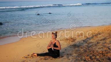 身穿黑色运动服的女士坐在海浪中沉思