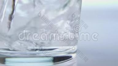 将新鲜纯净水倒入桌上的玻璃杯中，健康饮食理念.. 在白色背景上隔离。 慢动作