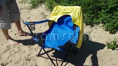 那个年轻人检查撕破的沙滩椅。 在该国度假期间<strong>设备损坏</strong>