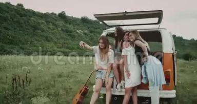 赛尔夫时代在田野的中间，一群年轻的女士坐在一辆复古<strong>面包车</strong>的后面拍照。