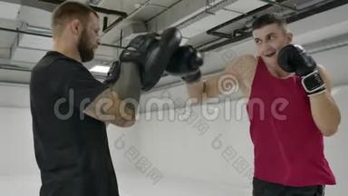 男式拳击手与教练练习的技术打击和躲避打击慢动作。 筹备
