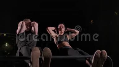 运动情侣一男一女一起在腹肌上做一个运动，把身体的概念<strong>放到</strong>腿上坐一个
