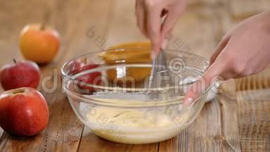 将煮<strong>好的</strong>手和搅拌<strong>好的</strong>搅拌<strong>好的</strong>黄油。 女人在家做苹果蛋糕。