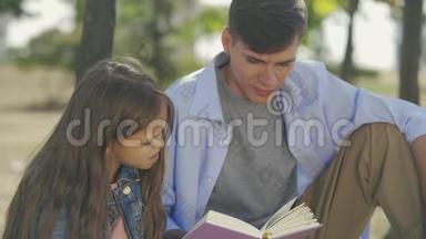 一个十几岁的小男孩和他的小妹妹一起看书，在阳光明媚的秋日里坐在公园里，写着诗或故事