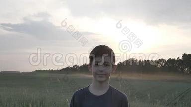 一个<strong>天真</strong>易受骗的男孩在麦田里看日落时的镜头的肖像