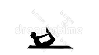 剪影运动肌肉年轻瑜伽男子做后弯运动，达努拉萨纳，弓姿势。