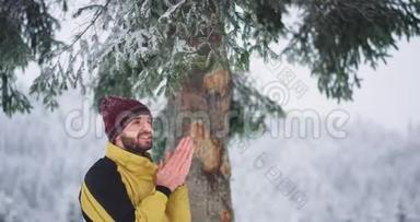 有魅力的游客在山上旅行，他在大雪树下停了一会儿，高兴地享受着这一刻