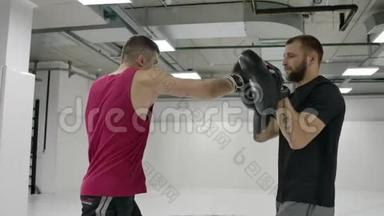 男式拳击手与教练练习的技术打击和躲避打击慢动作。 筹备