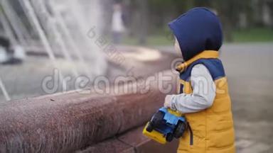 那孩子在喷泉边玩。 孩子们`快乐，快乐的童年.. 家庭价值观