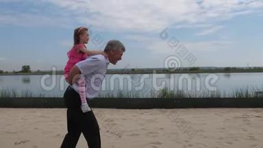 照相机在动. 那个女孩背着孙女沿着海滩跑。 小女孩很高兴。 4K慢