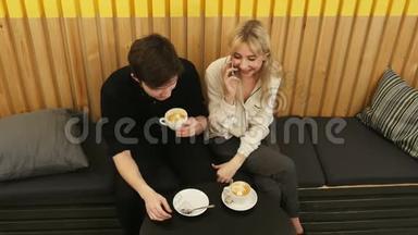 年轻开朗的女人在咖啡店约会时通过手机聊天