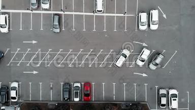 在商务中心附近的汽车停车场的空中俯视，有停放的汽车商务舱。 无人机在停车场上空飞行