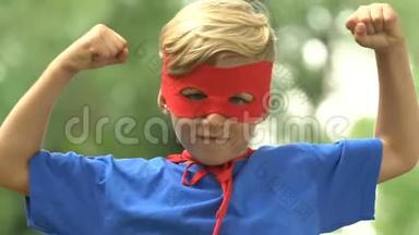 强壮的超级男孩戴着面具和服装，表现出力量、自信