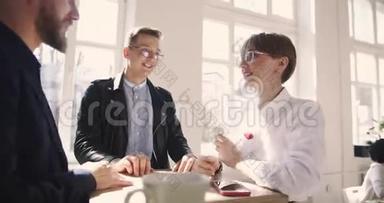 快乐的不同年龄男女商务人士在舒适时尚的办公室正式交谈。