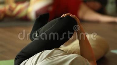 女人臀肌伸展瑜伽躺在垫子上
