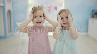 两个小女孩站在镜头前傻笑