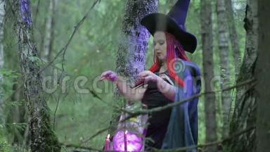 一个红头发、黑<strong>帽子</strong>、黑斗篷的年轻女巫正在森林里施展<strong>魔法</strong>