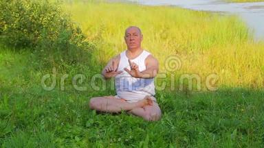一位中年男子早上在湖上做呼吸瑜伽和冥想