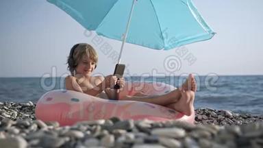 可爱的<strong>孩子</strong>在智能手机上听音乐，在海滩上<strong>唱歌</strong>