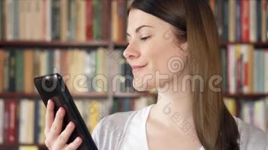 女大学生在大学图书馆使用电子书。 背景书架