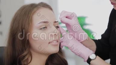 专业化妆师用<strong>棉签</strong>给客户处理眉毛。