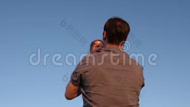 幸福的一家人晚上在天空中玩耍。 爸爸把他的孩子扔在蓝天上爸爸玩一点