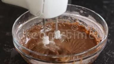 用可可<strong>搅拌</strong>巧克力面团。 巧克力面团在玻璃碗中与<strong>搅拌</strong>机混合。