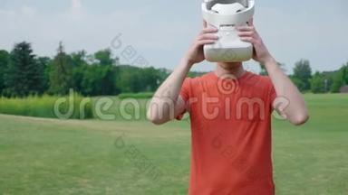 一个男人把<strong>VR</strong>耳机放在头上，在公园里<strong>玩</strong>虚拟游戏