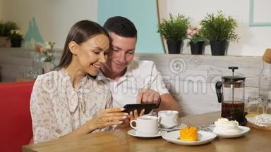 女孩和男孩在糖果店的餐桌上看手机