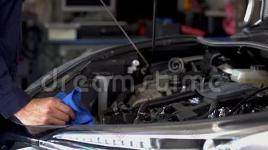 技师检查汽车发动机油尺油位的手