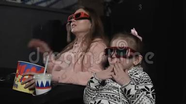 妈妈和女儿正在电影院看3d电影。 情感-惊喜