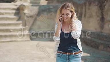 一位年轻的金发女子天生美丽，在手机上与世界边缘的朋友和家人交谈。 A.