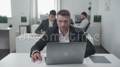 平日在办公室，男人在笔记本电脑前工作。