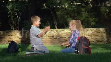 快乐的男生和女生在<strong>放学</strong>后坐在公园里玩拍手游戏