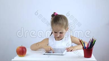 小女孩坐在书桌前，在平板电脑上<strong>完成任务</strong>