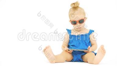 戴墨镜的严肃宝宝在现代智能手机上看电影或卡通