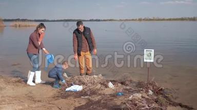 环境保护，男孩帮助家庭志愿者积极分子清理污染的河滩塑料垃圾和
