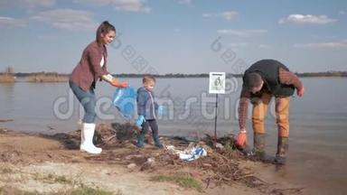 爱护自然生态，家庭志愿者带着小儿子在肮脏的水边清理塑料和聚乙烯垃圾